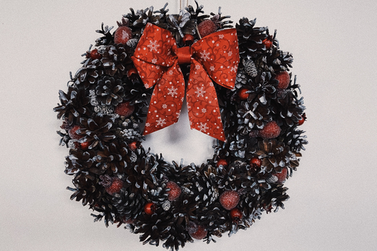 A christms decoration a Chritmas wreath with a red ribbon